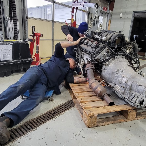 (Service Technician David Long (top) and Master Technician Paul Staubs (bottom) salvage a transmission from a wrecked Dodge Charger vehicle to be reused. (5 March)